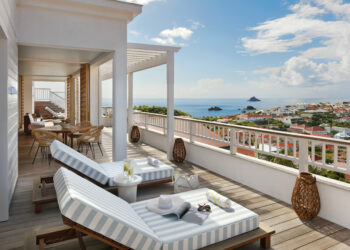 Une terrasse avec de confortables chaises longues et une vue sur la mer turquoise