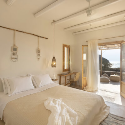 Une chambre aux teintes claires ouvrant sur une terrasse donnant sur la mer Egée, sur l'île grecque de Kea
