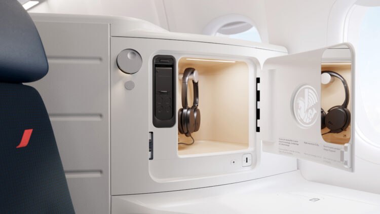 Un coffre ouvert avec des écouteurs et un miroir de courtoisie près d'un fauteuil, dans la nouvelle cabine Business Class d'un avion Air France