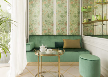 un petit salon Tata Harper au Spa Le Bristol by La Prairie avec du papier peint fleuri et un canapé en velours vert
