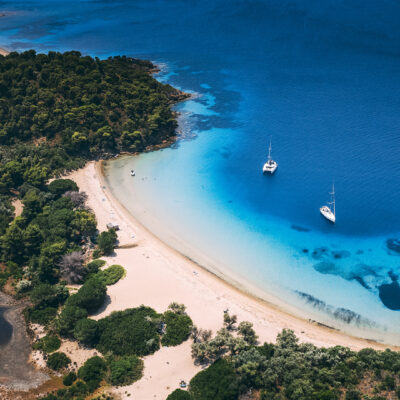 Croissant de sable blond sur fond de mer Egée turquoise, à Skiathos en Grèce
