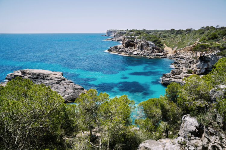 Vue d'une calanque rocheuse d'Ibiza avec végétation méditerranéenne et mer turquoise