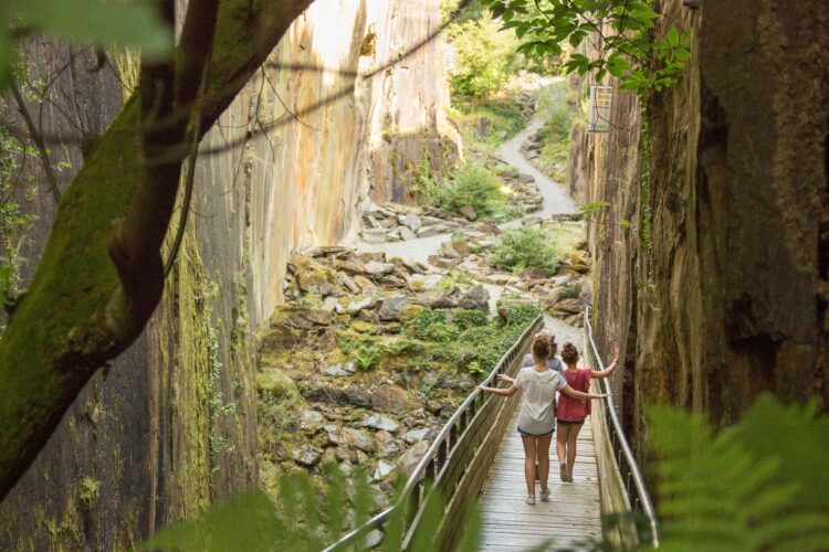 Deux enfants qui descendent une passerelle le long des pans de Travassac, une carrière que l'on peut visiter lors d'un séjour à Brive