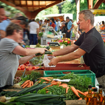 Deux personnes devant un étal de légumes au marché de Brive