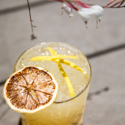 Un cocktail signature avec une rondelle de citron posé sur une table de la plage privée de Nikki Beach, à St Tropez