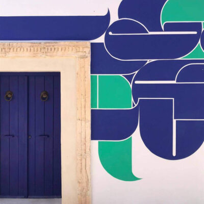 Ile de Djerba, en Tunisie: une maison traditionnelle avec une porte bleue marine et un graff stylisé bleu marine et turquoise