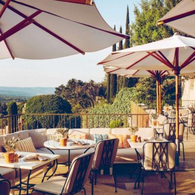 Une table dressée sur une terrasse de l'hôtel Crillon le Brave avec vue sur un jardin méditerranéen
