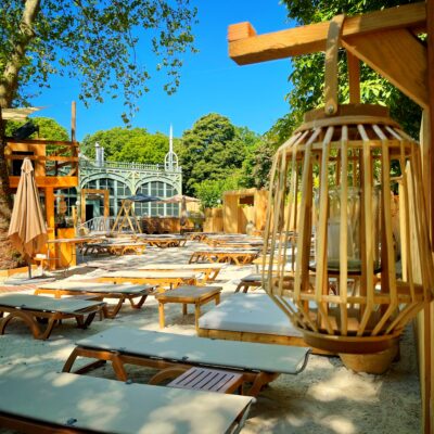 Des transats alignés sur le sable clair de La Beach Parisienne, une plage privée à Paris