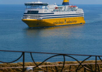 Une terrasse sur laquelle se trouve une table dressée pour le déjeuner, d'où l'on a une vue sur la mer et un navire de la Corsica Ferries