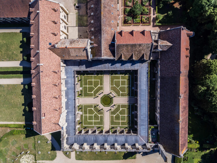 Vue aérienne des toits orangées de l'abbaye de Royaumont, avec en son coeur, un cloitre dont le jardin à la française fait la ronde autour d'un bassin