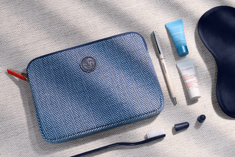 La trousse de toilette bleue proposée aux passagers Business des vols long-courriers Air France, avec une brosse à dents, deux crèmes Clarins, un stylo, un masque de nuit et deux bouchons d'oreilles. 