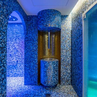 L'intérieur de centre de bien-être de l'Hôtel Martinez à Cannes, avec une pièce toute couverte de mosaïques bleues et une fontaine à glace pour se rafraîchir en sortant du hammam ou du sauna