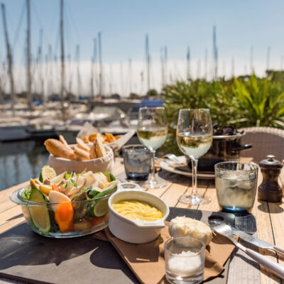 Une table dressée avec une salade de fruits de mer, dans l'un des restaurants face aux bateaux de plaisance amarrés dans le port de l'île des Embiez