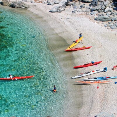 Des canoës colorés hissés sur une crique de sable clair bordée par une mer turquoise, sur l'île des Embiez