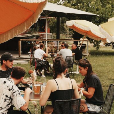 Des personnes qui boivent un verre dans le jardin de La Belle Saison, une guinguette de Bordeaux