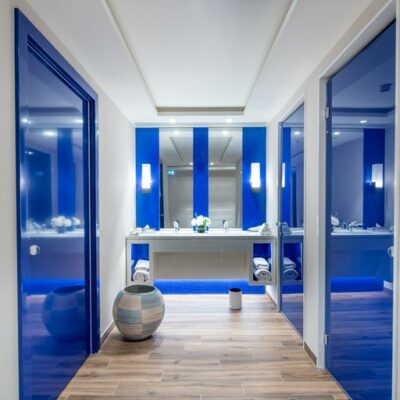 Un couloir bordé de portes laquées de bleues qui mènent aux cabines de soins du nouvel espace de bien-être de l'Hôtel Martinez à Cannes