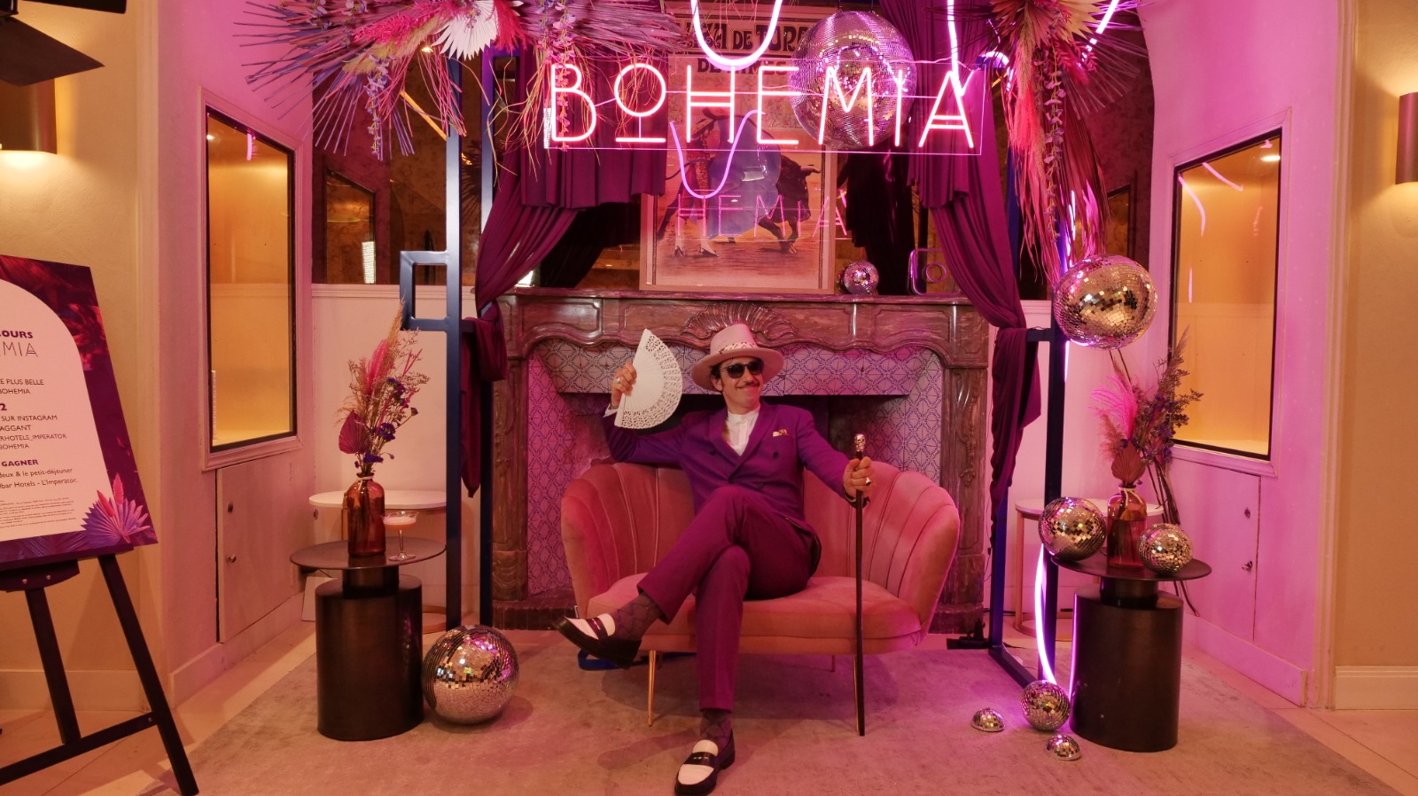 Nicolas Ullmann en costume violet, installé dans un fauteuil avec un éventail, lors de la soirée Bohemia organisée par l'hôtel L'Imperator lors de la Feria des Vendanges de Nîmes