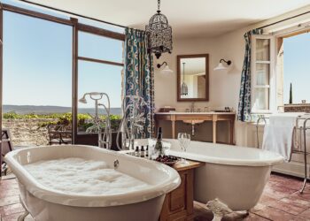 Deux baignoires remplies à ras bord avec du bain moussant dans une chambre de l'hôtel Crillon le Brave