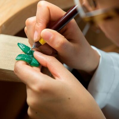 Détail d'un artisan joaillier en train de travailler minutieusement sur un papillon de jade Van Cleef & Arpels