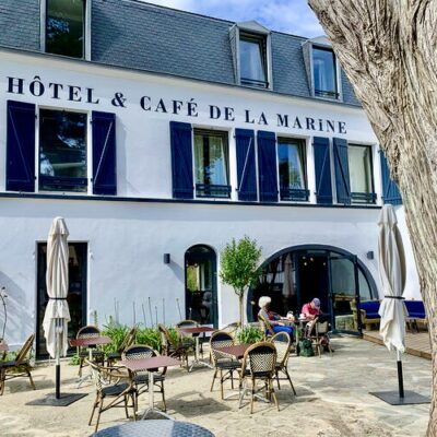 Vue de la façade blanche de l'Hôtel de la Marine, avec ses volets bleus marine et son toit d'ardoise, sur l'île de Groix