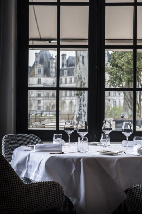 Le restaurant de l'hôtel de luxe le Relais de Chambord, dont les portes vitrées s'ouvrent sur les tours Renaissance du château de Chambord