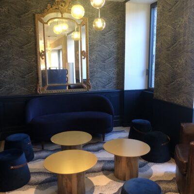 Velours bleus marine pour les poufs et canapés, tables, miroirs et luminaires dorés pour la déco du petit salon de l'Hôtel de la Marine, sur l'île de Groix
