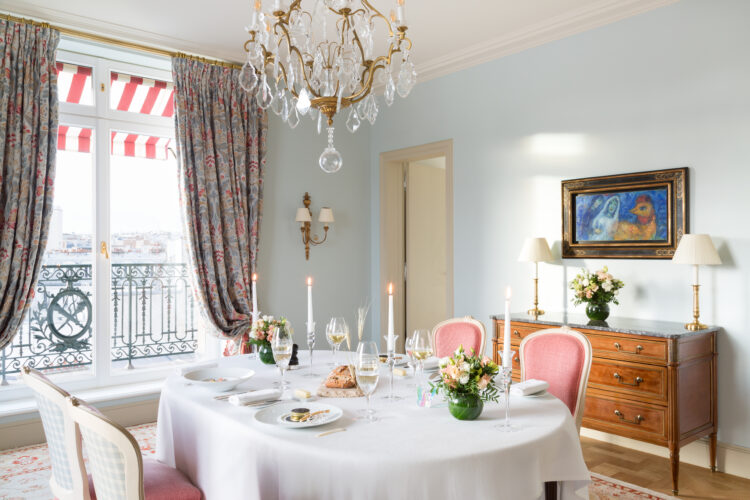 La salle à manger de la Suite Paris de l'hôtel Le Bristol Paris, avec une belle table dressée face à un tableau de Marc Chagall