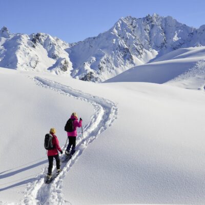 Deux randonneurs en raquette qui se promène dans les montagnes enneigées de l'Autriche