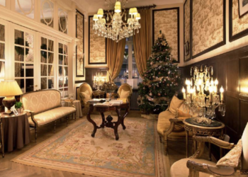 Un salon classique décoré de bougeoirs, lustre en cristal et sapin de Noël dans un Relais & Châteaux