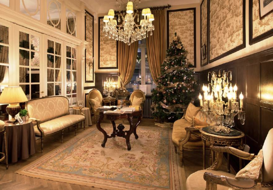 Un salon classique décoré de bougeoirs, lustre en cristal et sapin de Noël dans un Relais & Châteaux